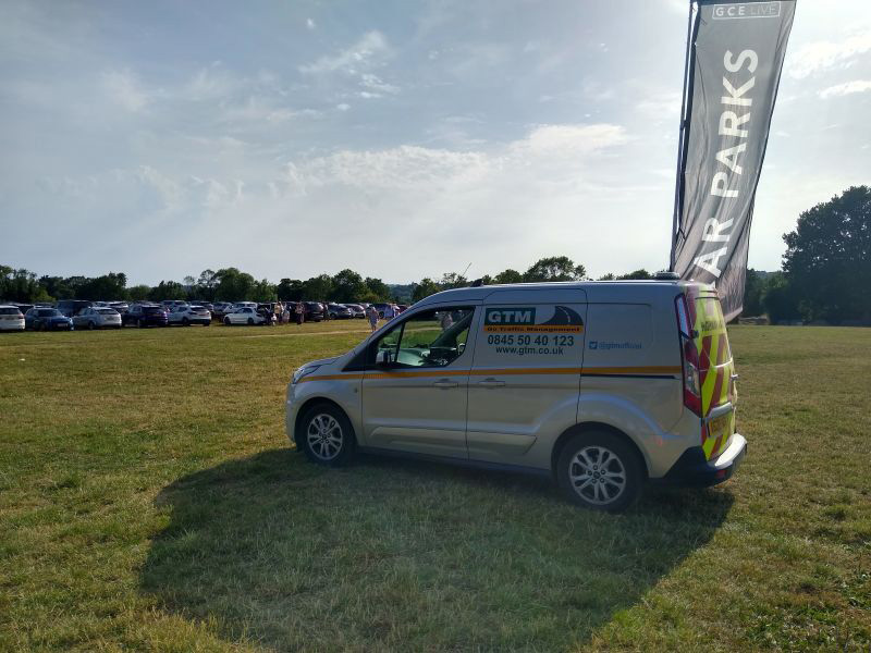 Go Traffic Management van on a field next to a car parks flag - managing event parking.