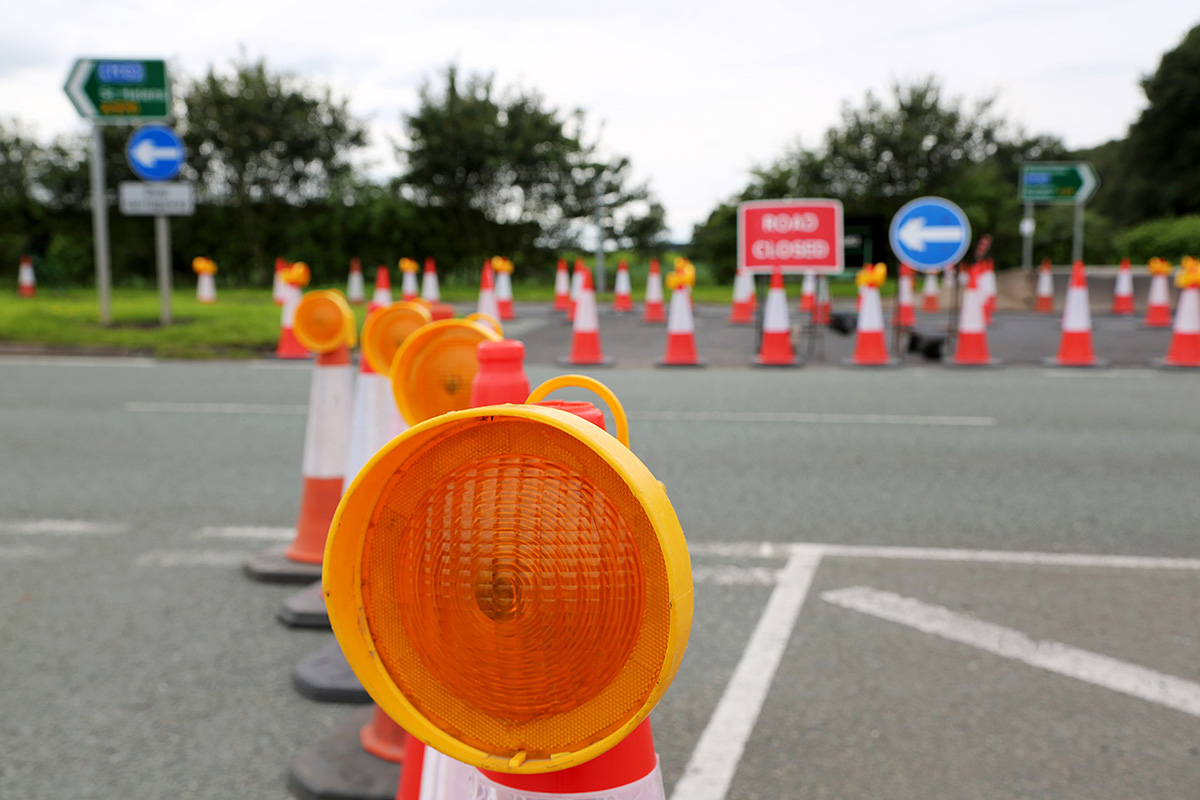 low speed road closure, cones and signs visible.
